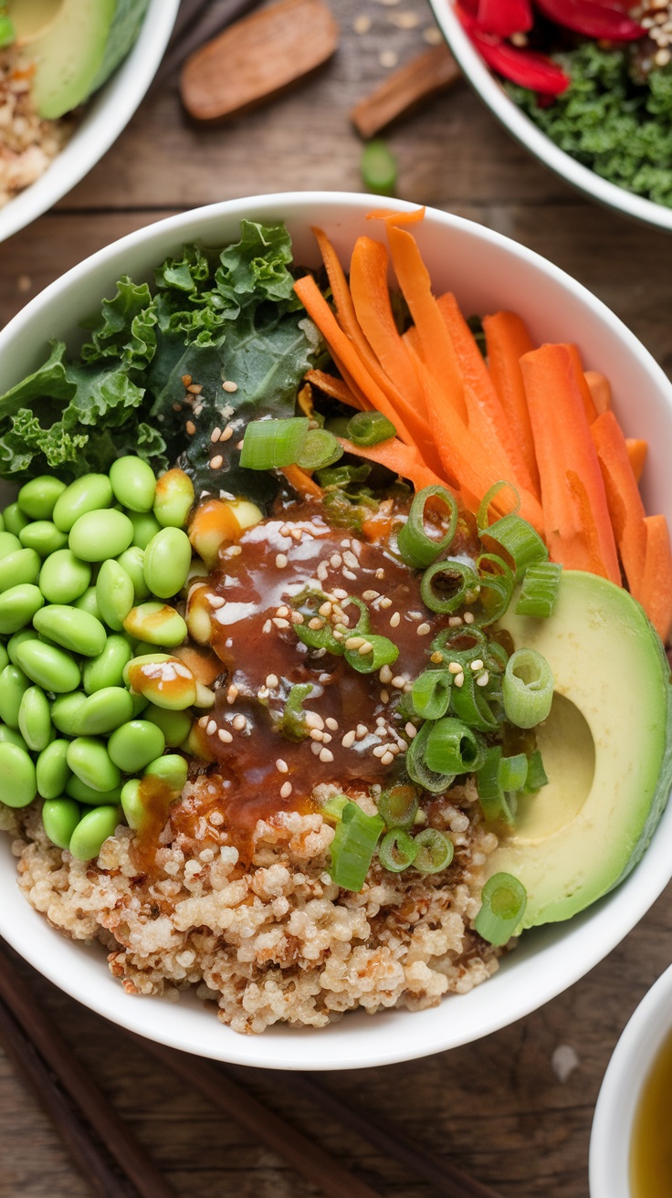 A colorful Vegan Buddha Bowl with quinoa, edamame, kale, carrots, bell pepper, and avocado, topped with Asian dressing and garnished with sesame seeds.